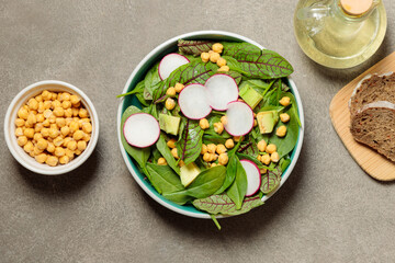 Fototapeta na wymiar Lunch with green salad and chickpeas. Close-up, top view on gray background