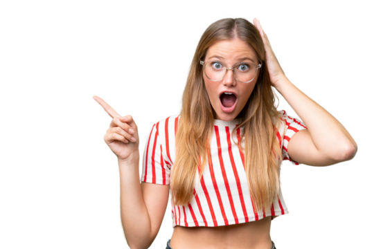 Young beautiful woman over isolated background surprised and pointing finger to the side