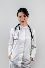  female doctor or nurse isolated on a plain background with a stethoscope around her neck.