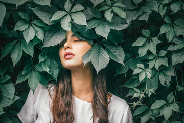 Beautiful fashion model girl enjoying nature, breathing fresh air in summer garden over Green...
