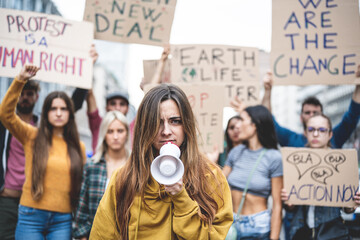 Protests about climate change, close-up of a young Gen Z girl with megaphone in her hand and severe...
