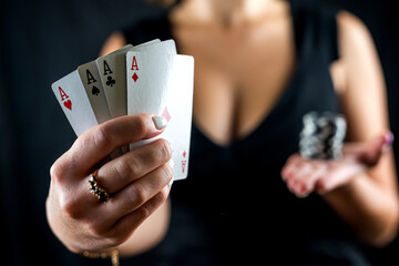 happy beautiful woman in a seductive dress plays poker at the casino table.