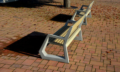 light concrete park bench, elegant cast frame and light wooden seat and backrest made of planks....