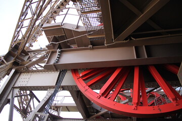 details of the red cogwheel of the metal construction of the eiffel tower