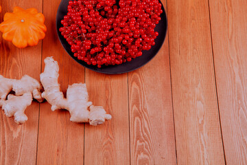 Still life with pumpkin- patison. Red viburnum berry, cranberry.Chicory root.Nuts. Autumn maple leaves.On a wooden background.meal.Thanksgiving day.the concept of fresh vegetables..place for text	