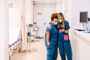Happy nurses using smart phone at hospital