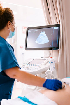 Mature nurse examining patient through ultrasound machine