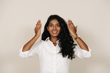 Young brunette indian woman smiling and expressing surprise