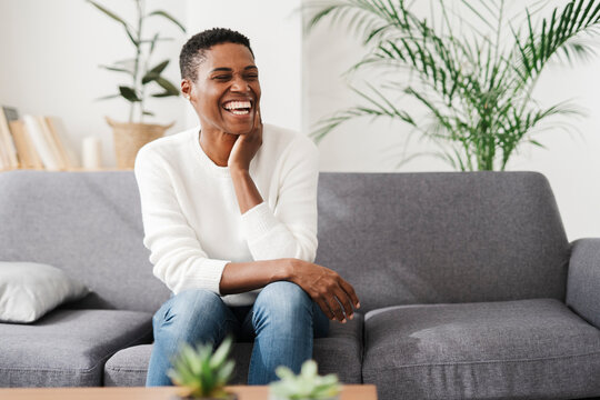 Laughing Woman Sitting On Couch At Home