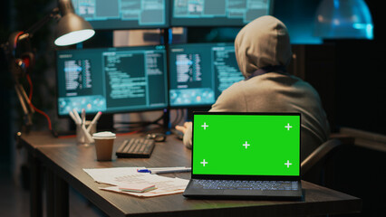 Young data thief using greenscreen to break into IT server, coding and programming on multiple monitors. Causing pc malware with virus, having isolated chroma key display and blank copyspace.