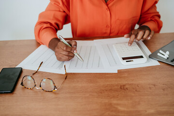 Businesswoman calculating financial bills at desk