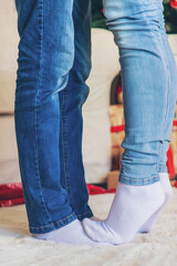 Legs of lovers near the Christmas tree. Selective focus.