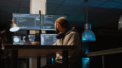 System programmer typing source code on laptop and multiple monitors, using programming language to create firewall security server. Coder developing database cloud computing. Handheld shot.