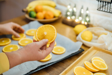 How to Dry Orange Slices for Eco friendly zero waste Holiday Decor. Close up Process of Drying Orange Slices in Oven. Woman cutting slices of orange and citrus fruits for drying in oven in kitchen