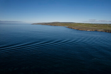 Aerial view on blue ocean water and Irish coastline and clean blue sky. West of Ireland. Irish landscape.