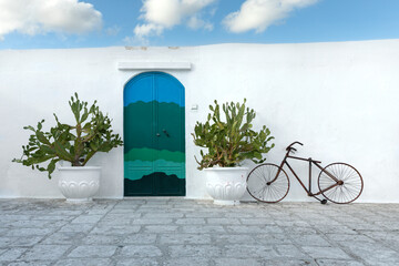 Fototapeta na wymiar Wand mit Kakteen, Fahrrad und Tür in Ostunia, Apulien, Italien