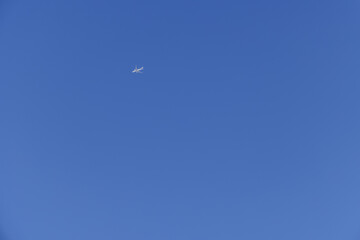 青空を飛ぶ白いジェット旅客機