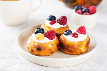 Traditional Russian, Ukrainian and Belorussian food cheese pancakes with blueberries, raspberries and sour cream.