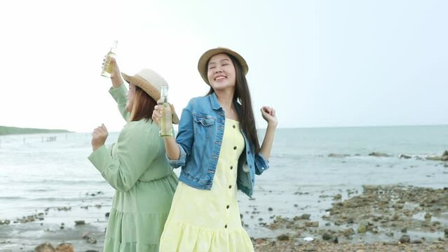 Cute picture of two girls dancing to celebrate the beach. Beautiful sexy girl with fat best friend Dancing, drinking wine by the beach on a beach day.