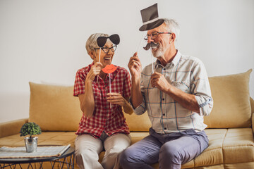 Happy mature couple is having fun at home.
