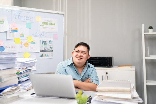 Portrait of Asian young businessman with down syndrome work in office. 