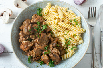 Creamy chicken stew with mushrooms and pasta on a plate