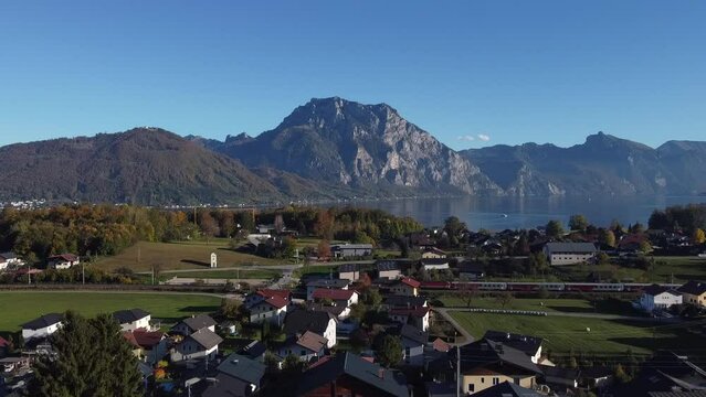 Mount Traunstein in Upper Austria on sunny day with train in the foreground  - drone footage