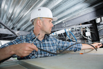 electrical worker wiring in ceiling