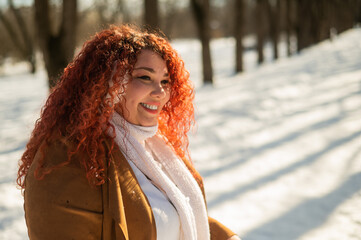 Cheerful fat caucasian woman in fur headphones outdoors. 