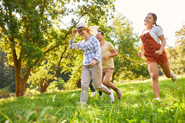 Fototapeta premium Happy family running across a meadow