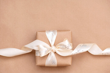 Beautiful paper gift box with a satin white ribbon on a neutral background. Flat design. copy space. Horizontal, banner, flyer
