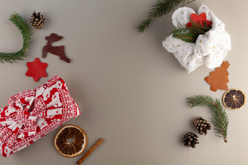 Eco-friendly Christmas composition with gift boxes made of eco-friendly reusable materials and natural decor on a gray background. The concept of Christmas with zero waste.