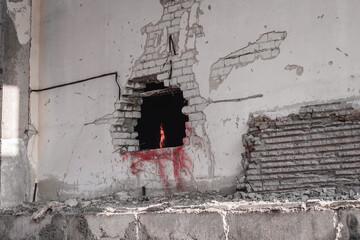 A broken wall of a house with a burning fire inside in the form of heating and room heating. Background