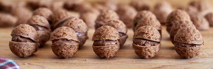 Horozintal banner with homemade nut shaped Christmas cookies filled with chocolate cream