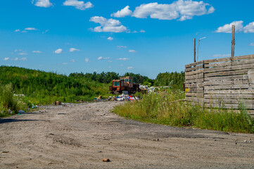Tractor picking up garbage at a public dump. Industrial waste. Garbage dump. Ecological...