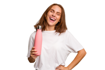 Young caucasian woman holding a pink thermo isolated laughing and having fun.