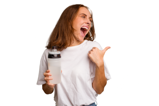 Young caucasian sport woman holding a bottle of water isolated points with thumb finger away, laughing and carefree.
