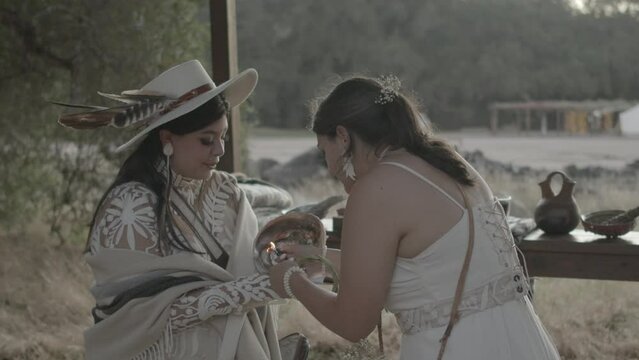 Two-spirit couple lighting for sacred smudging ritual at wedding