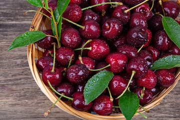 Ripe cherry in water drops on a wooden background, close-up