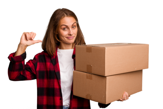 Young caucasian woman moving while picking up a box full of things isolated feels proud and self confident, example to follow.
