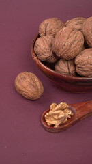 Closeup photo of a walnut seed in wooden bowl. Food that is good for brain and lower risk of heart disease.