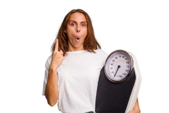 Young caucasian woman holding a scale and measure tape isolated having some great idea, concept of creativity.