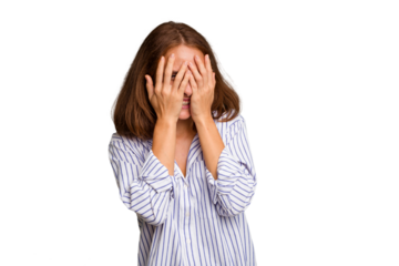 Young caucasian woman isolated blink at the camera through fingers, embarrassed covering face.