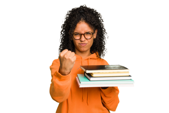 Young student woman holding a pile of books isolated showing fist to camera, aggressive facial expression.