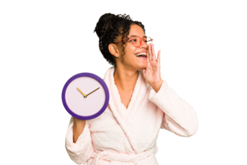 Young brazilian woman wearing a pajama holding a clock isolated shouting and holding palm near opened mouth.