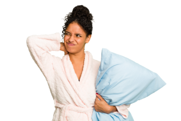 Young brazilian woman wearing a pajama holding a pillow isolated touching back of head, thinking and making a choice.