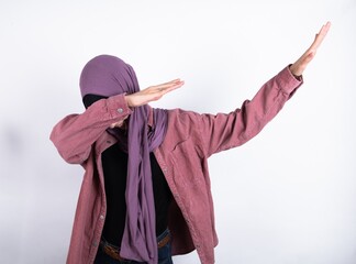 Photo of funky young beautiful muslim woman wearing hijab against white background show disco move dab