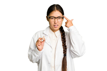 Young asian otorhinolaryngologist woman holding a hearing aid isolated showing a disappointment gesture with forefinger.