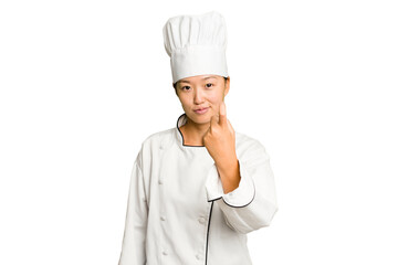 Young asian cook woman isolated pointing with finger at you as if inviting come closer.