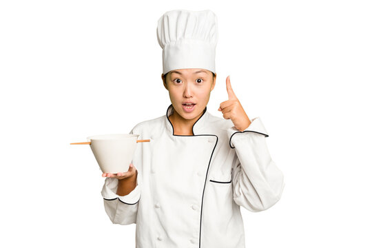 Young chef asian woman holding a bowl of ramen isolated having an idea, inspiration concept.